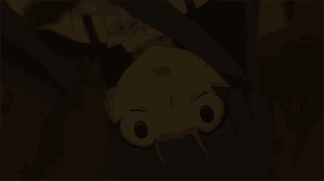 a cartoon character is upside down and looking at the camera in a dark room