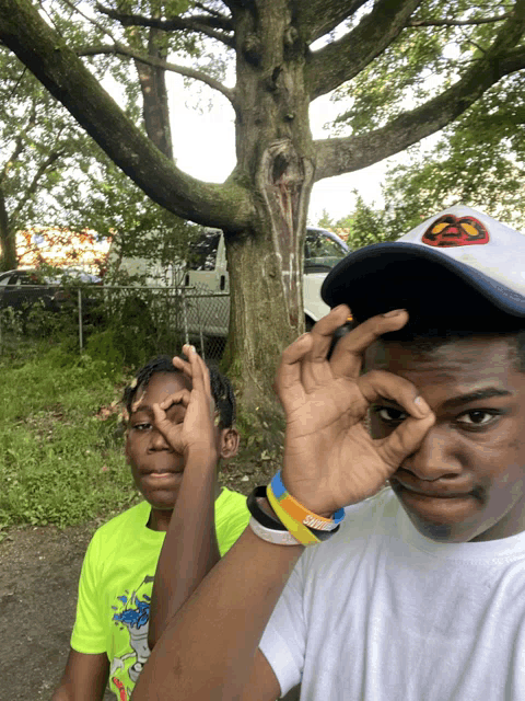a boy wearing a hat that says ' spiderman ' on it is making a funny face