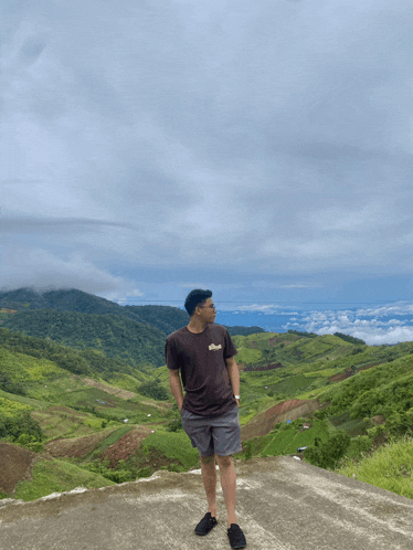 a man standing on top of a hill wearing a t-shirt that says ' abercrombie & fitch ' on it