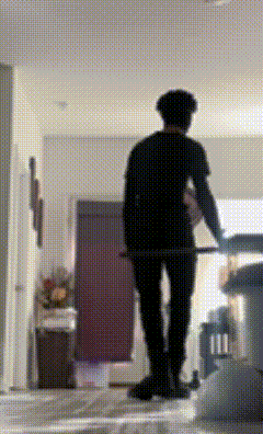 a man in a black shirt is walking down a hallway