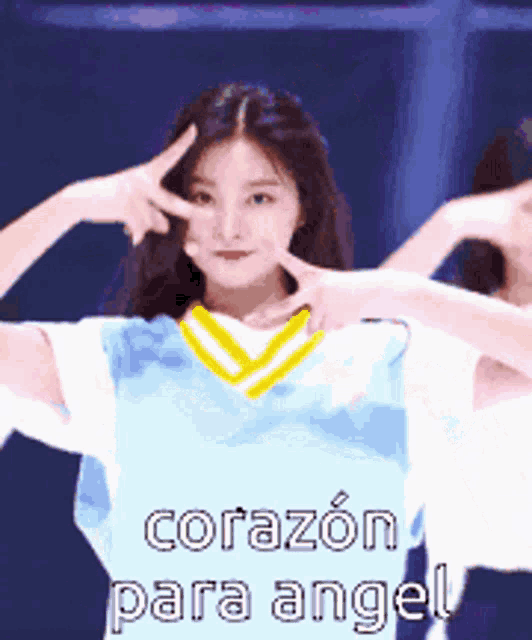 a girl in a blue shirt is making a peace sign with her hands .