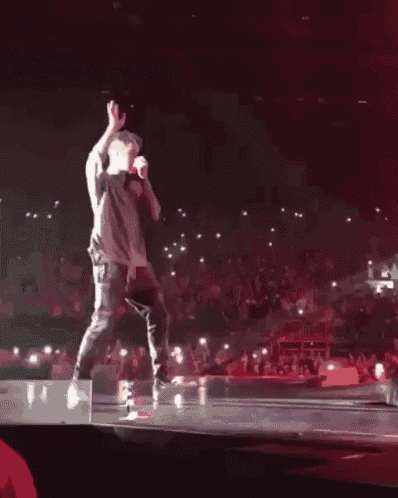 a man is standing on a stage with a microphone in his hand .