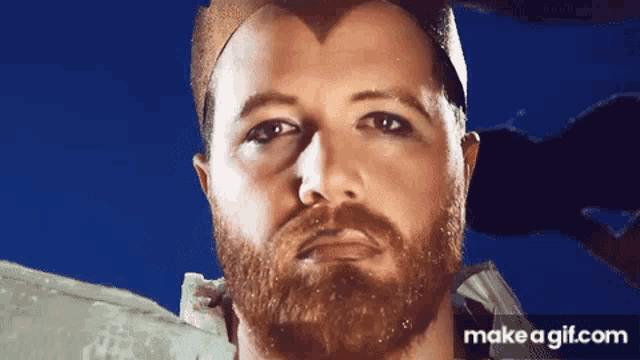 a close up of a man with a beard wearing a crown