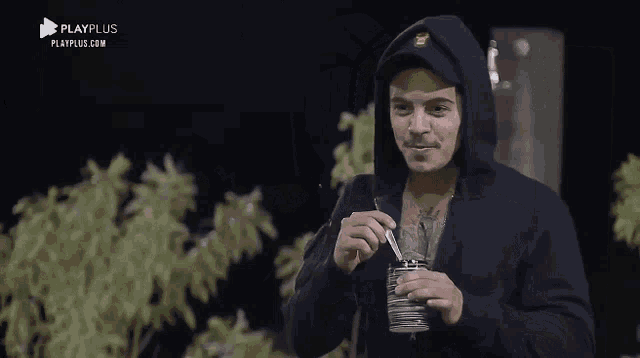 a man in a black hoodie is holding a stack of cards in his hand