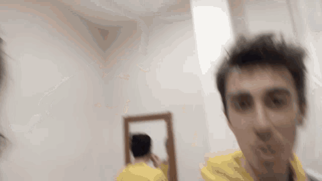 a blurry picture of a man looking at himself in the mirror