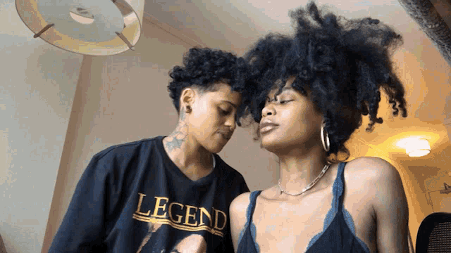 two women are looking at each other and one is wearing a legend shirt