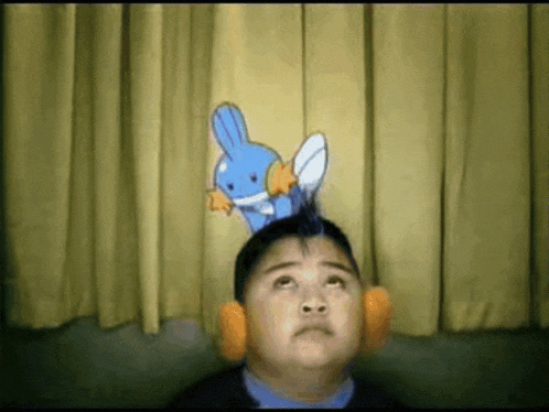 a boy wearing headphones looks up at a cartoon character on his head
