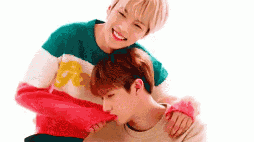 two young men are hugging each other and one of them is licking the other 's nose .
