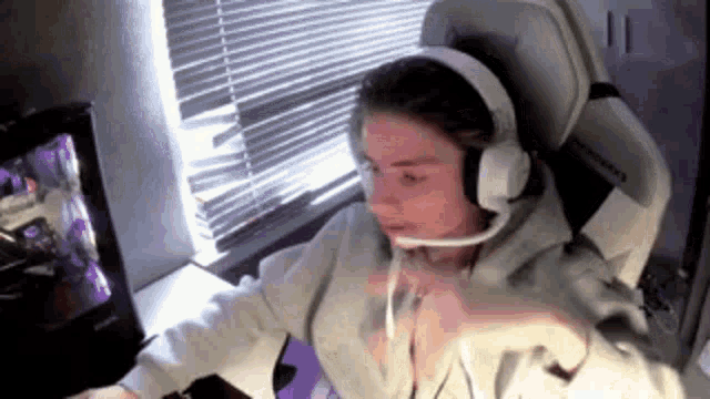 a man wearing headphones and a microphone is sitting in front of a computer .