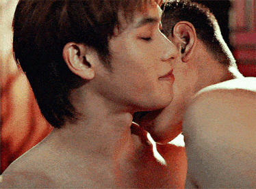 a man kissing another man 's neck in a close up