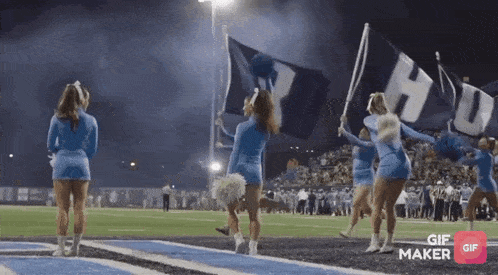 a group of cheerleaders holding flags that say hu