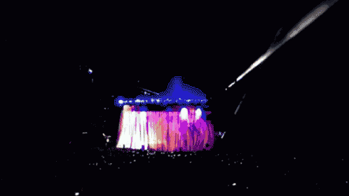 a crowd of people watching a concert with a huge explosion in the middle