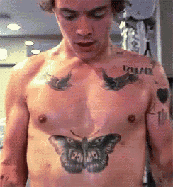 a man has a butterfly tattoo on his chest .