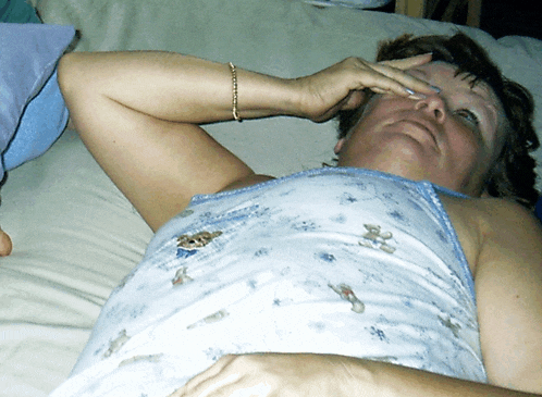 a woman is laying on a bed with her hand on her face