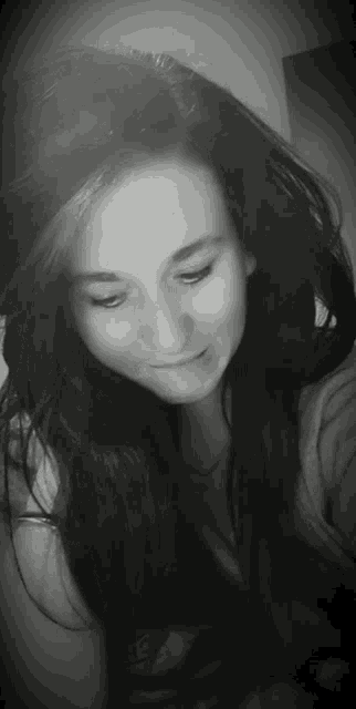 a black and white photo of a woman with long hair .