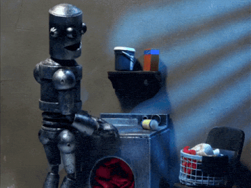 a robot standing next to a laundry machine