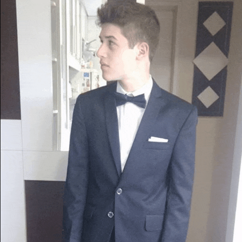 a young man wearing a suit and bow tie