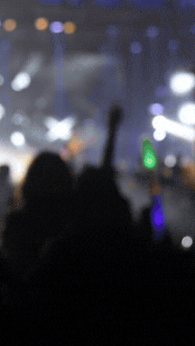 a blurry picture of a crowd with a green light in the middle