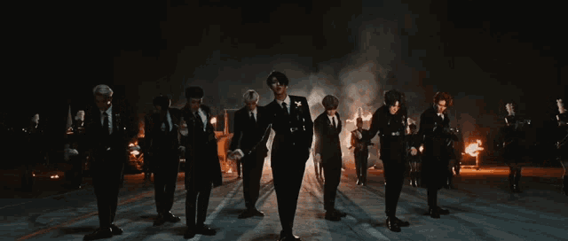a group of people are standing in a dark room with smoke coming out of them