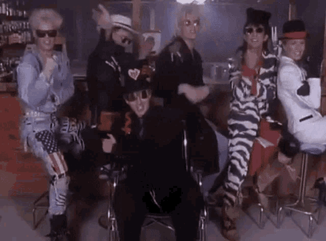 a group of people are dancing together in a bar .