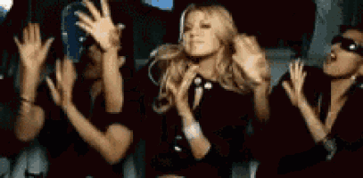 a group of people are dancing in a dark room .