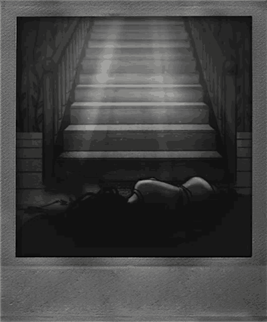 a black and white photo of a woman laying on the floor under stairs