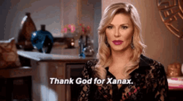 a woman is sitting in a living room and says thank god for xanax .