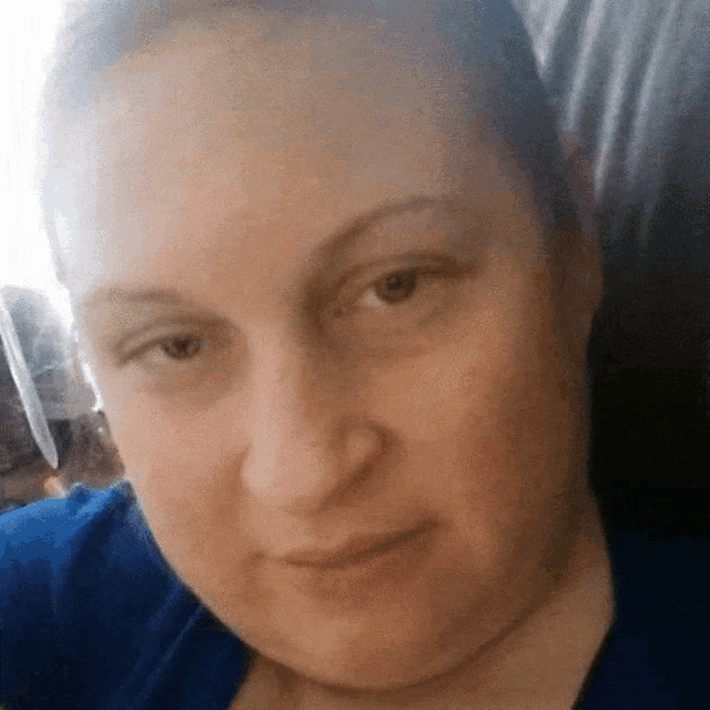 a close up of a woman 's face with a blue shirt