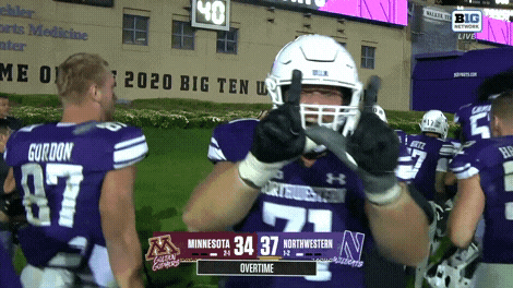a football player giving a thumbs up in front of a scoreboard that says big ten live