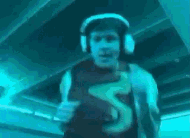 a man wearing headphones and a number 5 shirt is running .