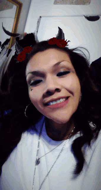 a woman with horns and roses on her head smiles