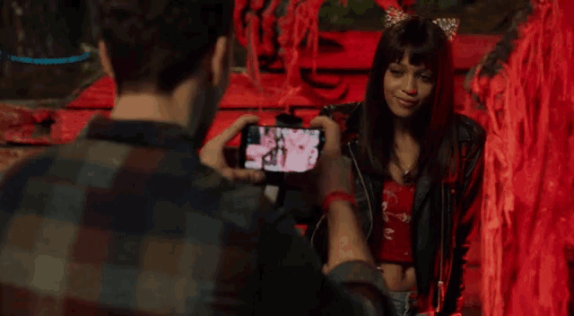 a man is taking a picture of a woman in a cat costume