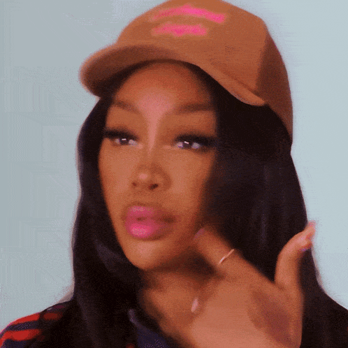 a close up of a woman wearing a hat with a pink lip