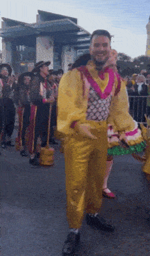 a man in a clown costume is dancing in a parade