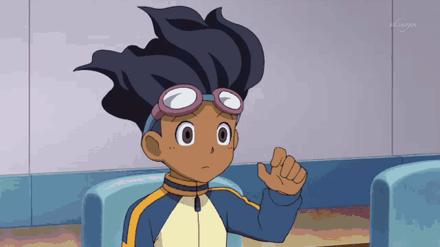 a boy wearing goggles is sitting in front of a tv screen that says tv tokyo