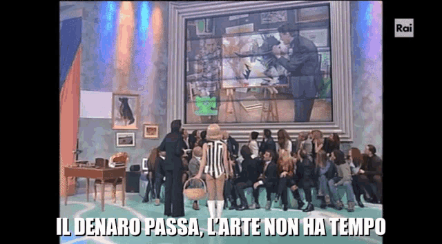 a group of people are standing in front of a large screen that says il denaro passa