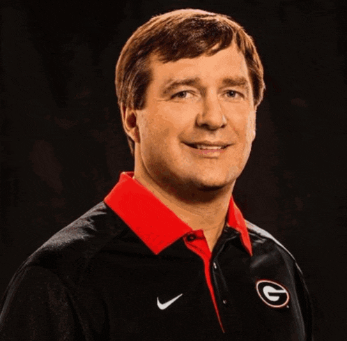 a man wearing a black nike shirt with the letter g on the front