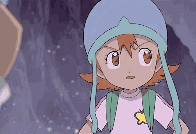 a girl in a pink shirt with a yellow star on it is wearing a blue hat