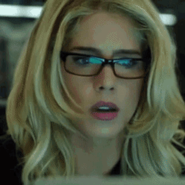 a close up of a woman wearing glasses and a surprised look on her face