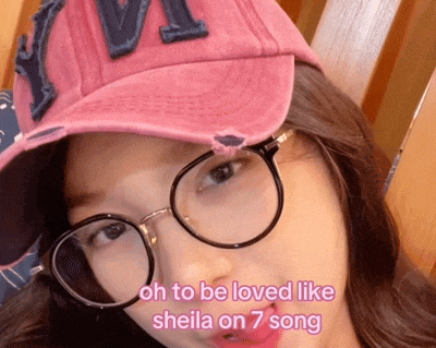 a woman wearing glasses and a pink hat with the words oh to be loved like sheila on 7 song