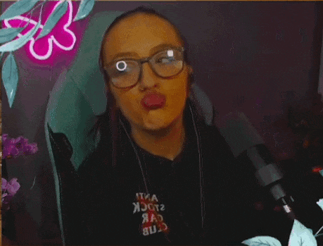 a woman wearing glasses and headphones is blowing a kiss