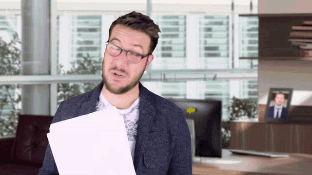 a man wearing glasses holds a piece of paper in front of him