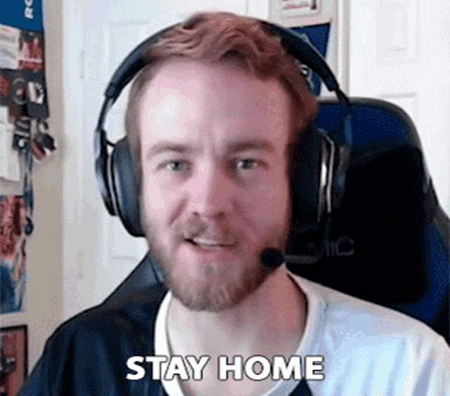 a man wearing headphones says " stay home "