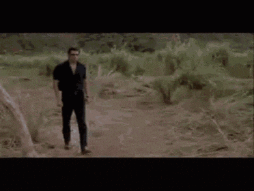 a man is standing in front of a pile of dirt