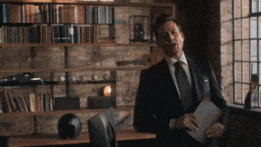 a man in a suit and tie holds a book