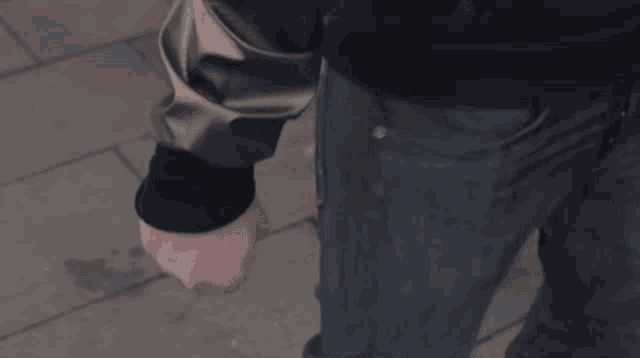 a man wearing a hooded jacket looks at a mask on another man 's face