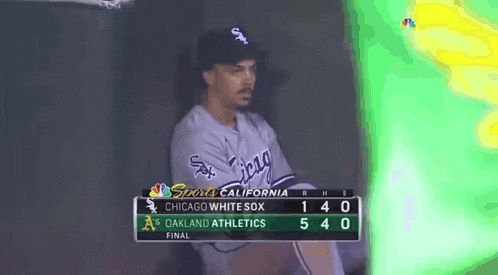 a chicago white sox baseball player sits in the dugout during a game against the oakland athletics