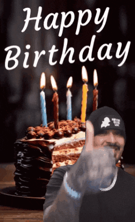 a man covering his face in front of a birthday cake