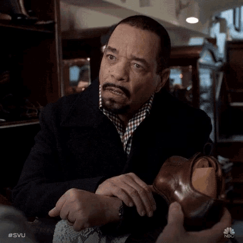 a man with a beard and mustache is holding a shoe in his hand with the hashtag #svu on it