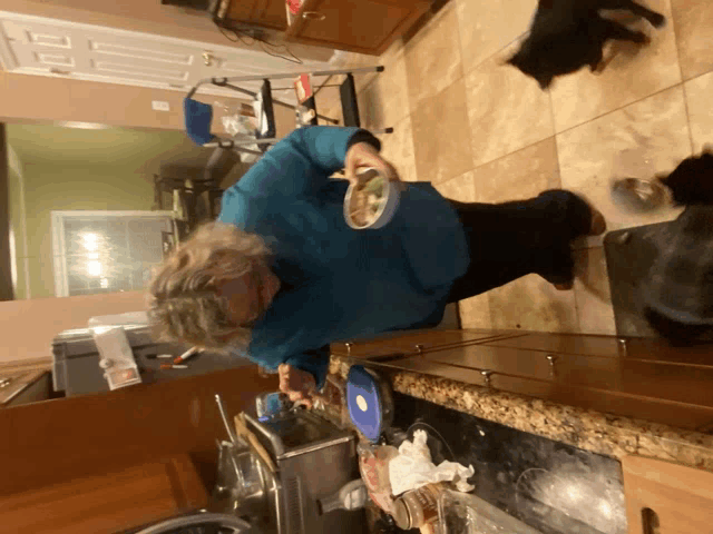 a woman in a blue shirt is holding a bowl of food